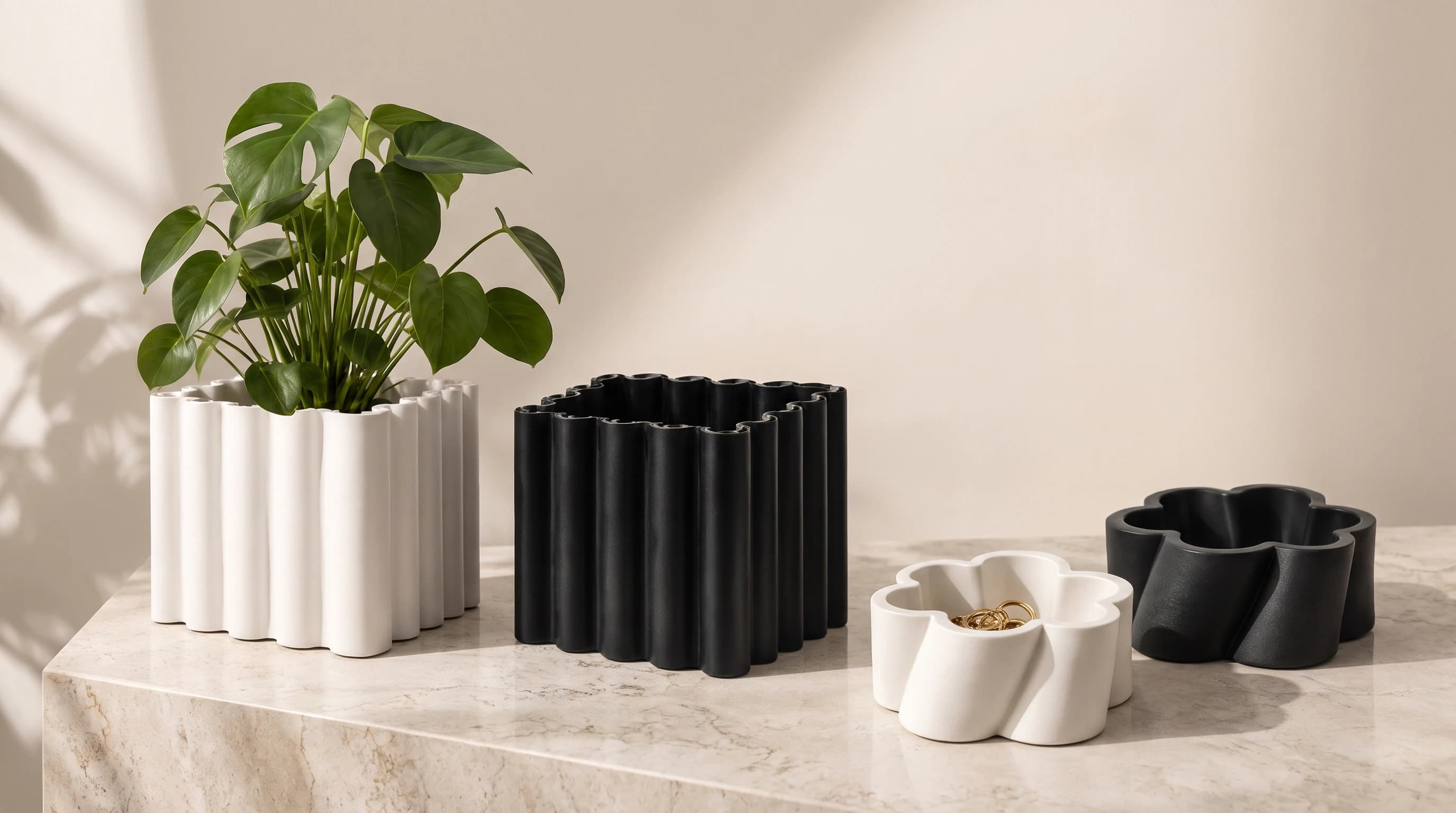 Vaso Tubi bianco e nero e Corolla bianca e nera su un piano in marmo, in luce naturale